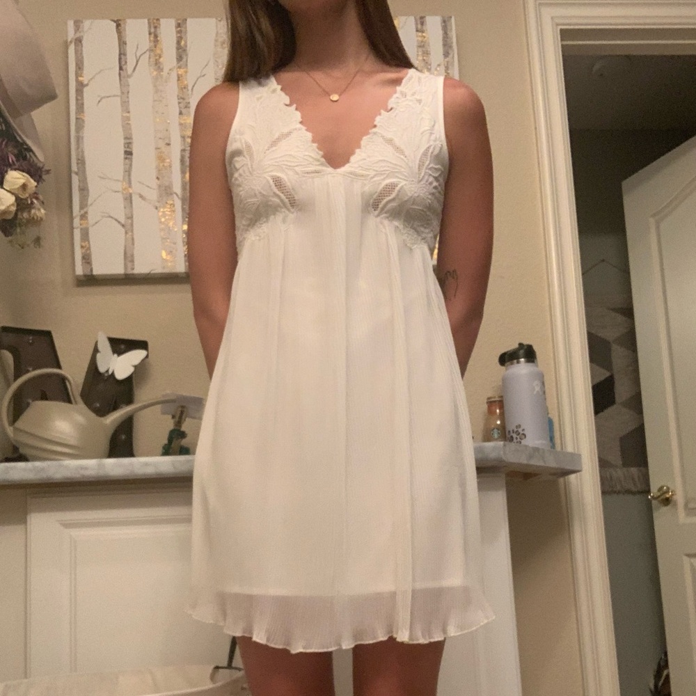 White crinkled mid dress with flower design top.